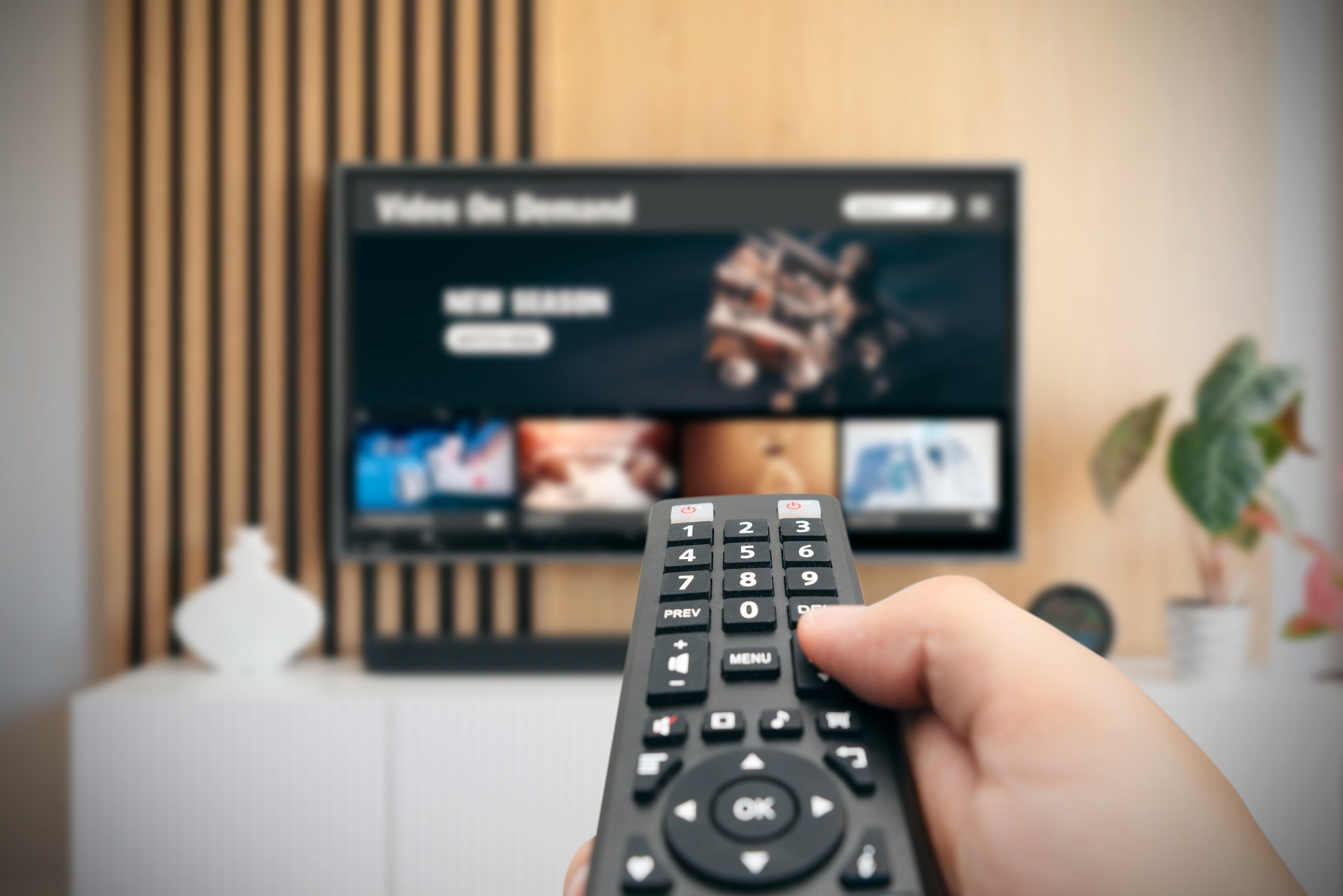 Man Watching TV with Remote Control in Hand.